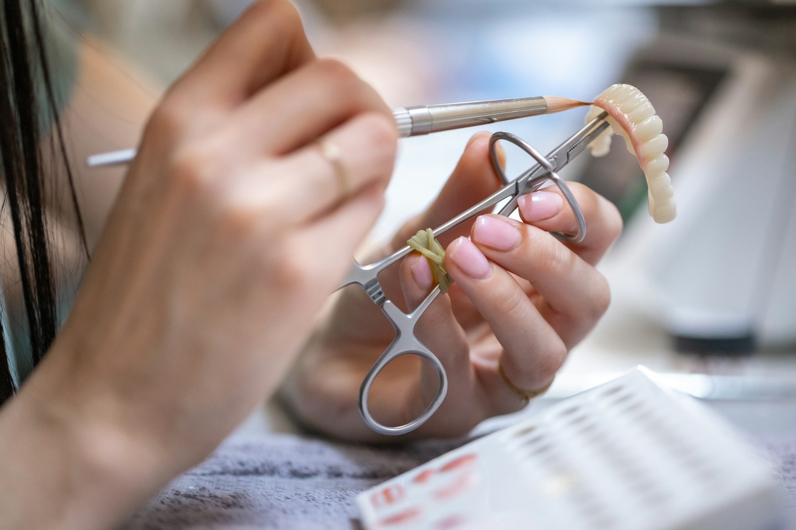 Dentist crafting a dental prosthesis with tools when comparing All-on-4 vs removable dentures